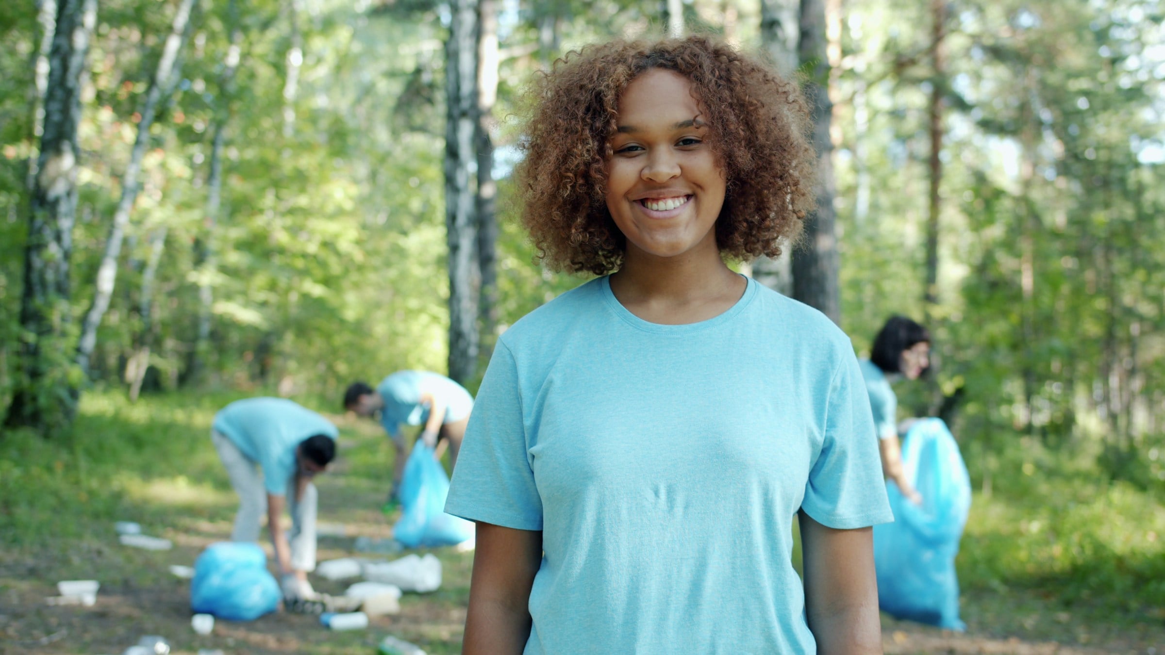 Young woman smiling while volunteering outdoors